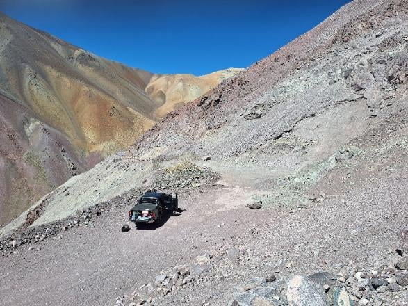 Vehicle on a drillpad cut into a hillside at Calaboso Prospect